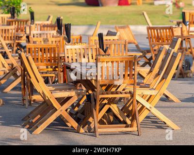 Teak furniture at an empty outdoor restaurant at a summer resort in Asia. Black chop sticks on each table. Stock Photo