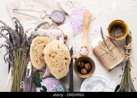Organic cosmetics concept, glass bottle with oil, pipette and lavander flowers, scrub on light background. Homemade cosmetics and beauty concept. Top Stock Photo