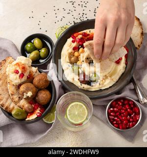 Bowl of fried falafel, pita and hummus dip. Middle Eastern cuisine snack on a light background. Top view. Stock Photo