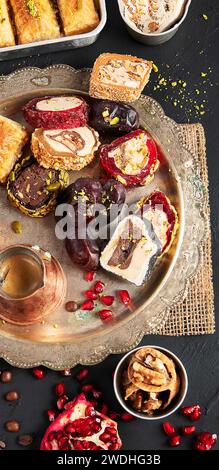 Hot tasty coffee with various pieces of turkish delight desets on a dark background. Traditional arabian food. Stock Photo