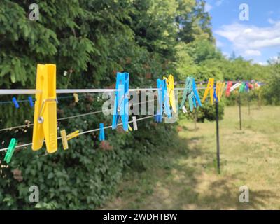 Colored laundry clothespins plastic. Hanging on clothesline, outdoors Stock Photo