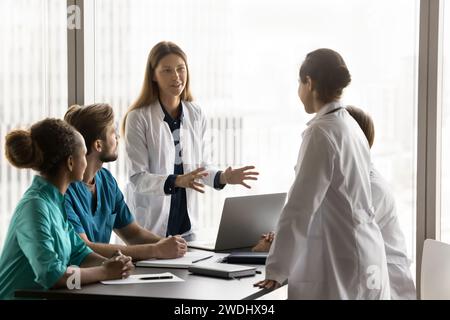 Two positive diverse female doctor colleagues discussing healthcare problems Stock Photo
