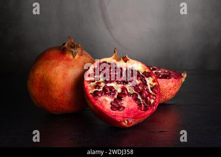 Pomegranate fruits on a graphite background. Fruit cross-section. Healthy food. Tropical fruits Stock Photo