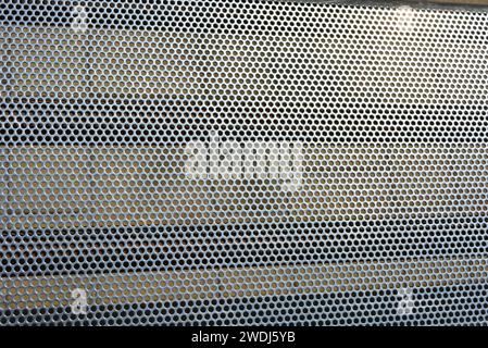 Metal mesh, background, with round identical holes, metal structure. Stock Photo