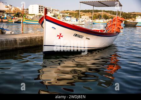 Marsaxlokk, Malta - 18 June 2023: typical Maltese boat, called luzzo, with the traditional eyes and Maltese cross drawn on the bow Stock Photo