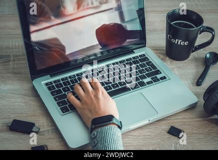 Girl using laptop with coffee cup and sd cards on the desk Stock Photo