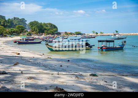 Fishing boats on the sea and beach of George Town city in the distance on the Strait of Malacca in Penang, Malaysia.  Stock Photo