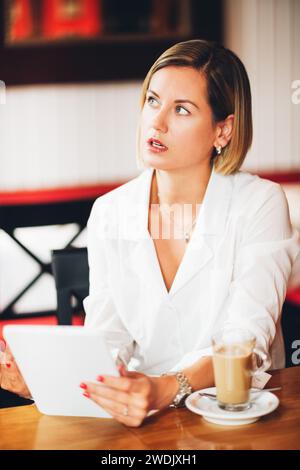 Beautiful young business woman working with tablet pc in a coffee shop Stock Photo