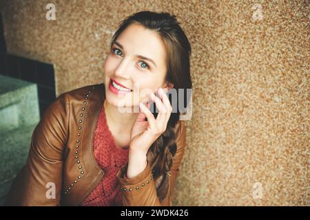 Close up portrait of beautiful young 25-30 year old woman with professional make up, wearing brown leather jacket Stock Photo