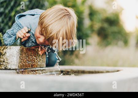 Little boy drinking from a water fountain Stock Photo