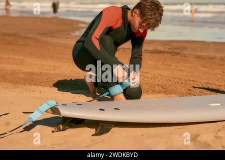 Surfer in wetsuit with surfboards is preparing for ride on waves Stock Photo