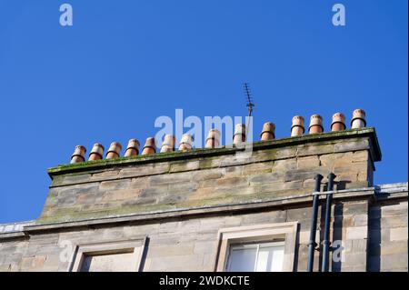 Chimney pots in a row on old victorian building roof Stock Photo