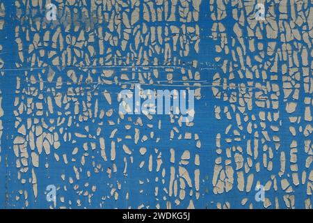 Cracked and weathered plastic wrap on metal surface. Abstract shapes grungy background. Stock Photo