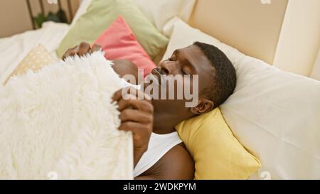 An african american man sleeping peacefully in a cozy bedroom with colorful pillows and blankets Stock Photo