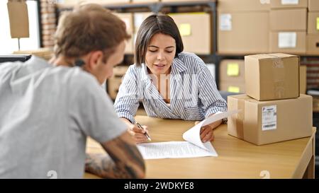 Two ecommerce business worker and client reading and signing contract at office Stock Photo