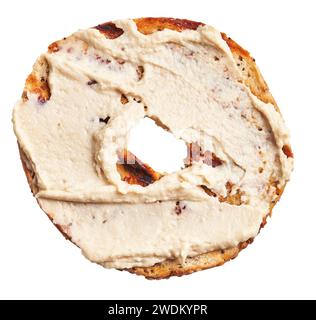 Close-up of a toasted cinnamon raisin bagel with cream cheese on a white background. Stock Photo