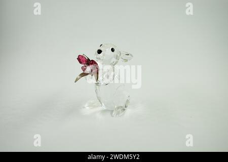 This adorable clear glass bunny holds a bouquet of tulips in Indian pink and light pink glass with silver tone metal stems. Stock Photo