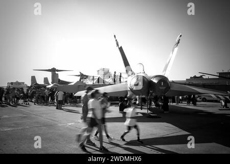 Airshow fans walk behind an F-18 Hornet at America's Airshow 2023 in Miramar, California. Stock Photo