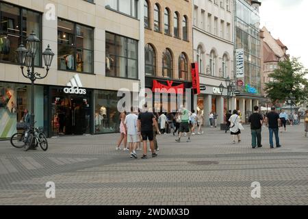 Various people are standing outside on Karolinenstraße with various department stores in the German city of Nuremberg. Stock Photo