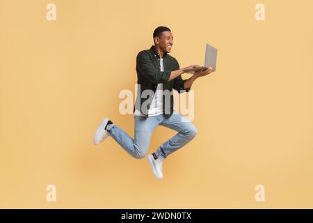 Excited young black guy independent contractor using computer Stock Photo
