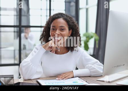Waist up portrait of cheerful young mixed race female with curly Stock Photo