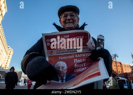 Moscow, Russia. 21st of January, 2024. Russian Communist supporter reads a campaign leaflet of the Nikolai Kharitonov presidential candidate of the Russian Federation as they walk to lay flowers at the Mausoleum of the Soviet founder Vladimir Lenin to mark the 100th anniversary of his death, in Red Square, Moscow, Russia. Credit: Nikolay Vinokurov/Alamy Live News Stock Photo