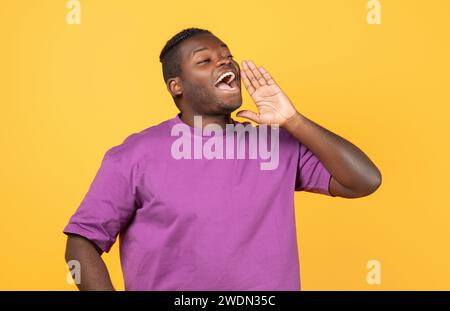 Black Guy Shouting Looking Aside Holding Hand Near Mouth, Studio Stock Photo