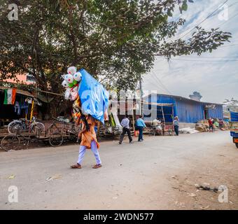 Local lifestyle: a local man walking in the street (Strand Bank Road) selling toys in Kolkata (Calcutta), West Bengal, India Stock Photo