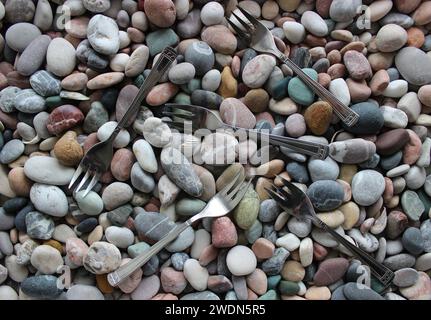 Same Three Pronged Forks Scattered On Smooth Sea Pebbles Top View Stock Photo Stock Photo