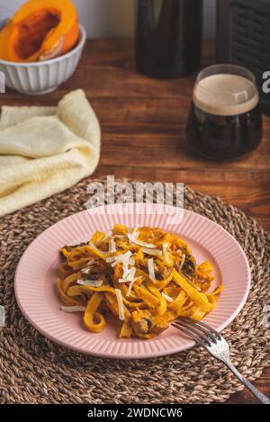 Tagliatelle Pasta with Creamy Pumpkin Sauce and Champignons Garnished with Grated Parmesan Cheese Stock Photo