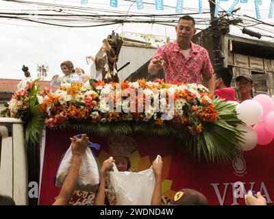 Malabon, Philippines. 21st Jan, 2024. Former Malabon City Mayor Antolin 'Lenlen' Oreta hands out candies during the Sto. Niño parade. The Feast Sto. Niño or the holy child Jesus is celebrated every third Sunday of January, The replicas are paraded all over the country. They symbolize the birth of Catholicism in the Philippines more than 500 years ago. Credit: SOPA Images Limited/Alamy Live News Stock Photo