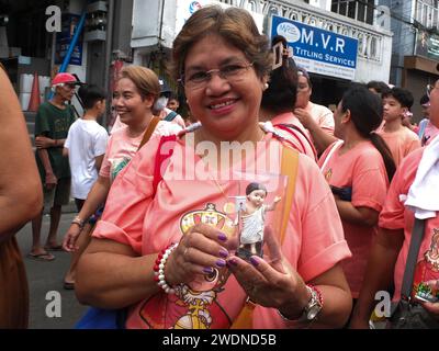 Malabon, Philippines. 21st Jan, 2024. A devotee shows her miniature Sto. Niño replica during the parade. The Feast Sto. Niño or the holy child Jesus is celebrated every third Sunday of January, The replicas are paraded all over the country. They symbolize the birth of Catholicism in the Philippines more than 500 years ago. Credit: SOPA Images Limited/Alamy Live News Stock Photo