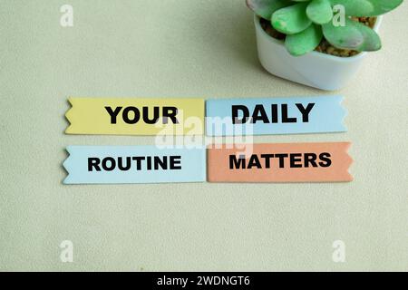 Concept of Your Daily Routine Matters write on sticky notes isolated on Wooden Table. Stock Photo