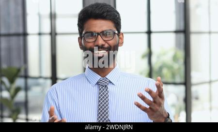 Confident elegant handsome young man standing in the office wearing a blue shirt Stock Photo