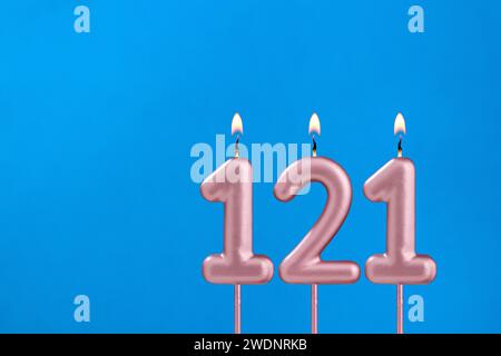 Birthday card with number 121 - Burning anniversary candle on blue background Stock Photo