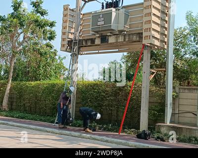 Electrician workers in overalls near an electrical transformer. maintenance and repair of electrical components. Mobile photo. Stock Photo