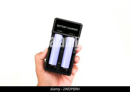 Battery charger isolated in hand on white background , battery charger for lithium ion battery rechargeable Stock Photo