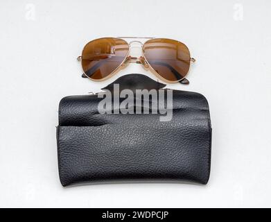 Ruined vegan leather black case with sunglasses on top Stock Photo