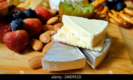 Some slices of Brie French cheese served with strawberries, almond and grapes Stock Photo