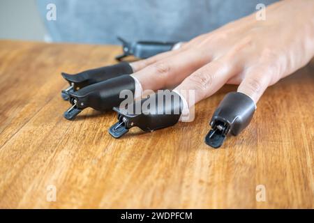 Tweezers for removing nail polish in the hands of a young woman who is waiting for the polish remover to work. Stock Photo