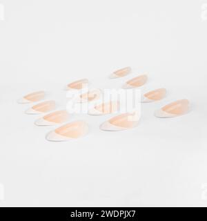 realistic set of colored false nails adhesive isolated on white background. top view. false nails acrylic nails for women. Stock Photo