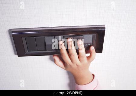 child finger turning on lighting switch with copyspace  Stock Photo