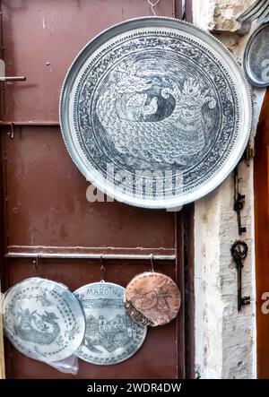 Metal tray engraved with the traditional figure of Mardin Shahmaran - a queen of Snakes, metal works kitchenware shop in Mardin Turkey Stock Photo