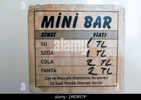 Mini fridge hotel price tag, handwritten: price on water, cola, soda in Turkish in TL Stock Photo
