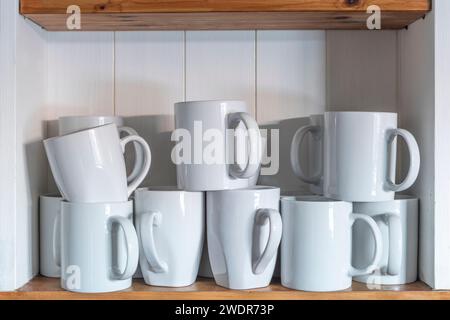 White coffee mugs on a shelving unit Stock Photo