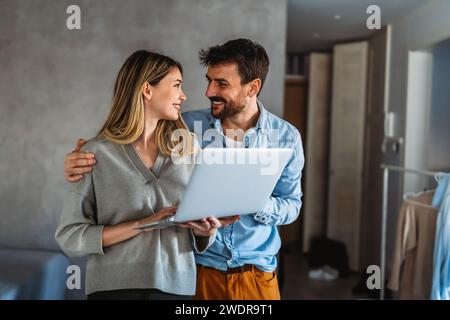 Couple of young designers working at modern home office, two coworkers discussing fun project Stock Photo