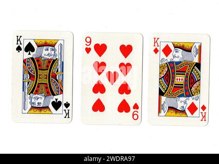 Vintage playing cards showing a pair of kings and a red nine isolated on a white background. Stock Photo