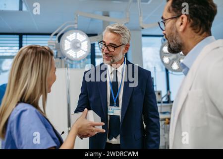 Pharmaceutical sales representative presenting new product to doctors in holding box with pills. Presenting new pharmaceutical product, drugs Stock Photo