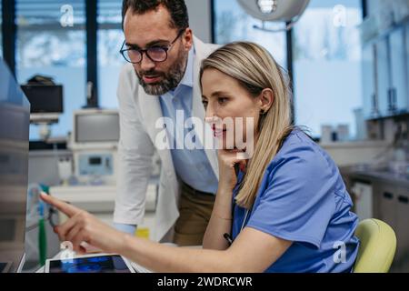 Pharmaceutical sales representative presenting new product to doctors in holding tablet. Presenting new pharmaceutical product, drugs, medication. Stock Photo