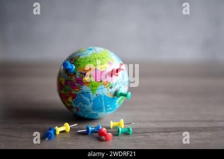 Closeup image of colorful pins on world globe. Travel destination, planning vacation concept. Stock Photo